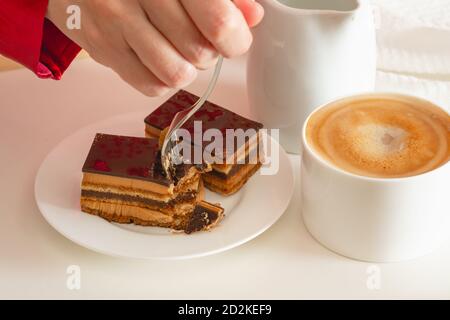 Tasse Kaffee mit Milch und Schokoladenkuchen. Süßes köstliches Frühstück auf einem Tisch mit Betttablett Stockfoto