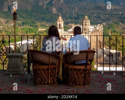 Ein Paar genießt ein romantisches Abendessen mit Blick auf das ehemalige Kloster in Tepoztlan, Morelos, Mexiko Stockfoto
