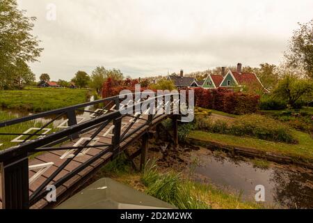 Landschaftsbild eines kleinen Dorfes in der Nähe von Den Haag, Niederlande mit einem kleinen Bach, Grasland, Sträucher, Bäume und Vintage traditionellen kleinen Hütten in Sicht Stockfoto