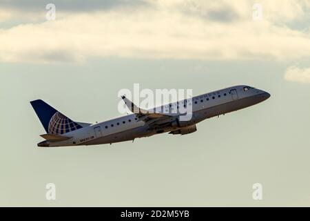 Washington DC, USA 10/03/2020: Ein Passagierflugzeug des Typs Embraer 175LR, das von United Airlines betrieben wird, steigt nach dem letzten Start in den Abendhimmel Stockfoto