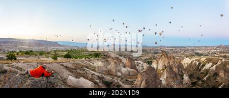 Ein Mann fotografiert Luftballons am Himmel über Kappadokien Stockfoto