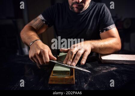 Der Mann mit Wetzstein zu schärfen Chef Messer Stockfoto