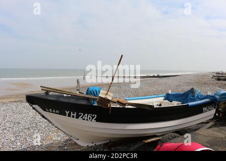 Fischerboote auf dem Sandstrand von Cromer an einem sonnigen Wintertag, Muschel Meer mit sanften Wellen krachend auf den Strand Stockfoto