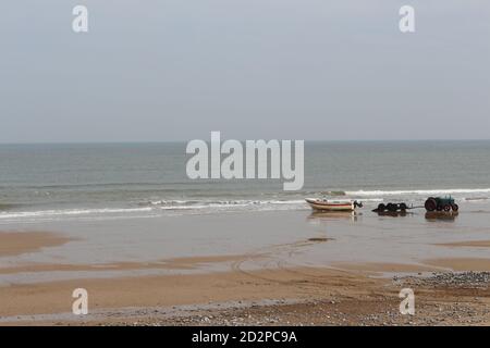 Fischerboote auf dem Sandstrand von Cromer an einem sonnigen Wintertag, Muschel Meer mit sanften Wellen krachend auf den Strand Stockfoto