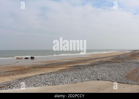 Fischerboote auf dem Sandstrand von Cromer an einem sonnigen Wintertag, Muschel Meer mit sanften Wellen krachend auf den Strand Stockfoto