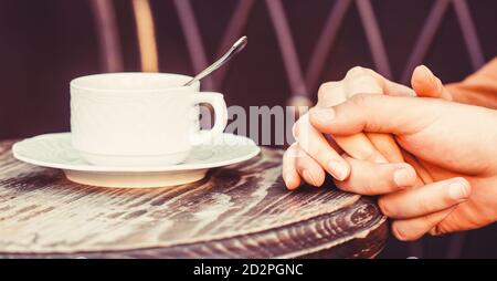Pärchen genießen Kaffee. Schönes Paar hält Tasse Kaffee in den Händen. Weibliche und männliche Hände halten Tasse Kaffee Stockfoto
