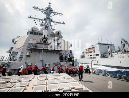 Seeleute „heaven“ auf einer Boten-Linie von der FOC ‘le an Bord der Arleigh Burke-Klasse Lenkraketen Zerstörer USS John S. McCain (DDG 56) während einer Nachschub-auf-See mit der Lewis-und Clark-Klasse trocken Fracht-und Munition Schiff USNS Charles Drew (T-AKE 10). McCain wird Destroyer Squadron Fifteen (DESRON 15) zugewiesen, der größten vorwärtseingesetzten DESRON der Marine und der wichtigsten Oberflächenkraft der US-Flotte der 7. Flotte. (USA Navy Foto von Mass Communication Specialist 2nd Class Markus Castaneda/veröffentlicht) Stockfoto