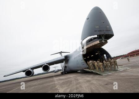 U.S. Army Soldaten aus der 3rd Combat Aviation Brigade und 3rd Sustainment Brigade, 3rd Infantry Division, versammeln sich auf der Laderampe einer C-5M Super Galaxy, um eine gemeinsame Luftlast Training mit den Airmen von der 3rd und 9th Airlift Squadrons, 621st Mobility Support Operations Squadron, Oktober 6, Hunter Army Airfield, Georgia. Diese Schulung ist von entscheidender Bedeutung, um sicherzustellen, dass die gemeinsamen Kräfte bereit sind, Ausrüstung sicher und effizient auf die Flugzeuge des Air Mobility Command zu laden, um eine schnelle globale Mobilität und eine Kraftprojektion zu gewährleisten. (USA Armee Foto von Sgt. Andrew McNeil 3rd Combat Aviation Brigade, 3 Stockfoto