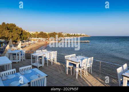 Strandrestaurant mit Meerblick bei Sonnenuntergang in Akyarlar Beach, Bodrum, Türkei. Stockfoto