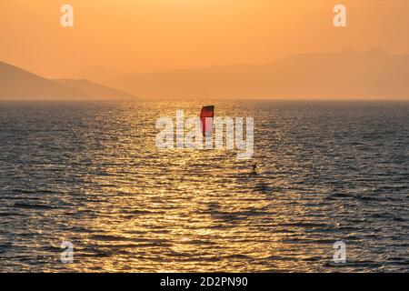Kitesurfen bei Sonnenuntergang im schönen Meer, auf der Insel. Stockfoto