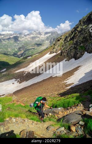 Escursionista ascendiendo el puerto, valle de Aygues Tortes, louron, cordillera de los Pirineos, Frankreich Stockfoto