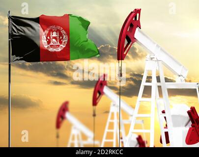 Ölbohrinseln vor dem Hintergrund des bunten Himmels und einer Fahnenstange mit der Flagge Afghanistans. Das Konzept der Ölproduktion, Mineralien, Entwicklung von Stockfoto