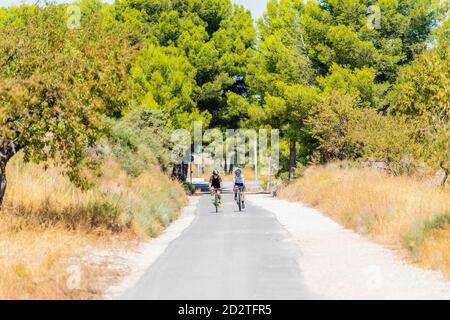Die ganze Länge der Radfahrer in Sportbekleidung und Helme zusammen Radfahren Auf asphaltierter Fahrbahn im Sommer auf dem Land Stockfoto