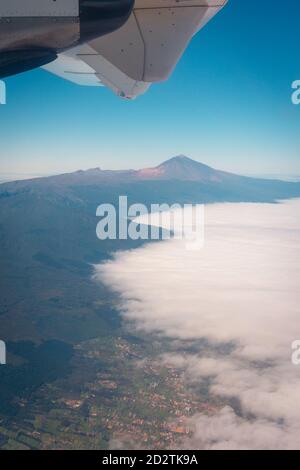 Luftaufnahme eines Teils der modernen Flugzeuge fliegen über erstaunlich Bergige Landschaft mit Wolken am Morgen in Teneriffa Stockfoto