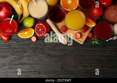 Gläser und Gläser mit verschiedenen Säften auf Holzhintergrund Stockfoto