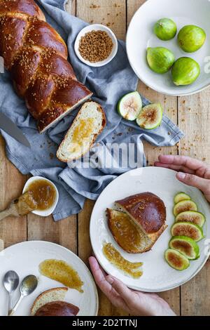 Draufsicht Zusammensetzung von geschnittenem geflochtenem Brot serviert mit frischem Feigen und süße Fruchtkonfitüre auf Holztisch Stockfoto