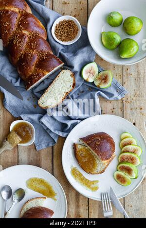 Draufsicht Zusammensetzung von geschnittenem geflochtenem Brot serviert mit frischem Feigen und süße Fruchtkonfitüre auf Holztisch Stockfoto