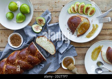 Draufsicht Zusammensetzung von geschnittenem geflochtenem Brot serviert mit frischem Feigen und süße Fruchtkonfitüre auf Holztisch Stockfoto