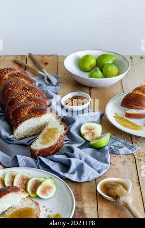 Draufsicht Zusammensetzung von geschnittenem geflochtenem Brot serviert mit frischem Feigen und süße Fruchtkonfitüre auf Holztisch Stockfoto