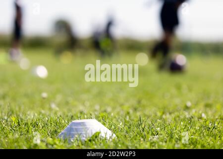 Verschwommener Hintergrund des Trainingsfußballfeldes. Sport Fußball Gras Veranstaltungsort. Training Fußball Marker auf dem Rasen. Laufen Fußballer in verschwommen BA Stockfoto