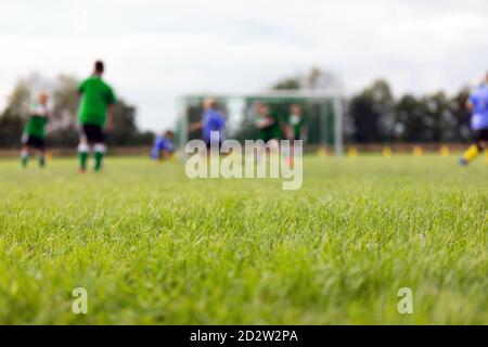 Verschwommener Hintergrund des Fußballfeldes. Jungen spielen Fußballspiel. Kinder in zwei Mannschaften spielen Turnierspiel Stockfoto