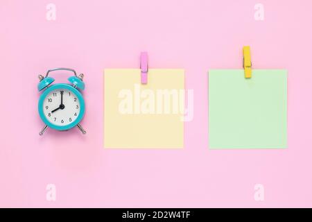 Zwei leere Aufkleber auf Tafel, Planungskonzept, Termin. Für Text platzieren, Platz kopieren. Buntes Notizpapier mit Wäscheklammern auf rosa Hintergrund. Stockfoto
