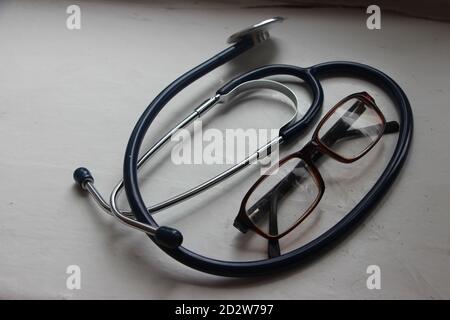 Arzttisch Draufsicht. Set aus verschiedenen Arzt-Zubehör auf einem farbigen Hintergrund. Pillen, Brille, Stethoskop und Notizbuch. Stockfoto