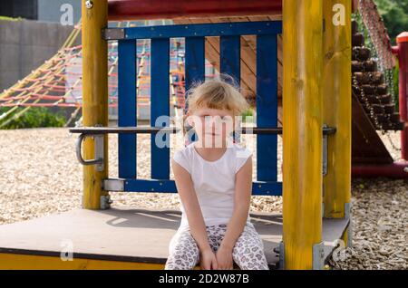 Schöne blonde Mädchen spielen auf dem Spielplatz Stockfoto