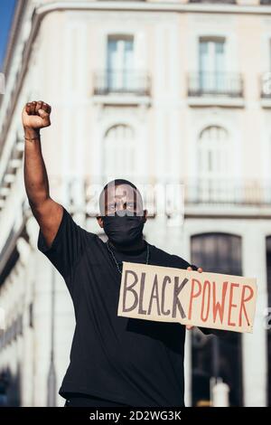 Ein Mann, der bei einer Kundgebung für Rassengleichheit mit einem „Black Power“-Poster protestierte. Schwarze Leben Sind Wichtig. Stockfoto