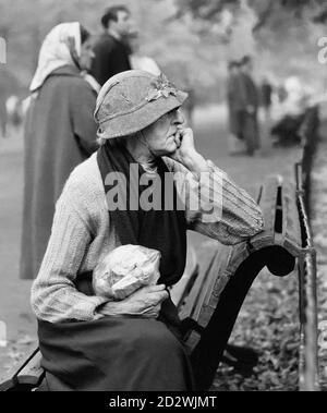 Rentner im Alter, der auf einer Parkbank in London sitzt. Stockfoto