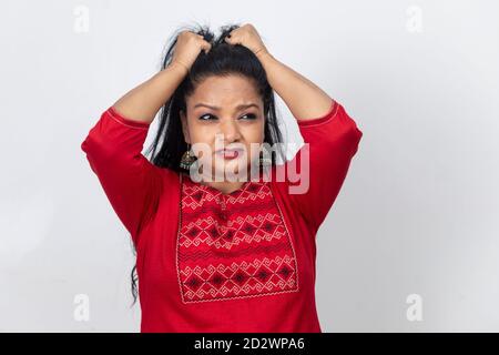 Porträt einer indischen Frau mit ihren Fingern in ihren langen Haaren und an ihnen ziehen, wütend und frustriert Dame. Stockfoto