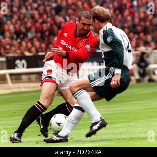 Eric Cantona von Manchester United (links) spielt den Ball in der ersten Hälfte des FA Cup Finales im Wembley Stadium um Liverpools John Skalen. Stockfoto