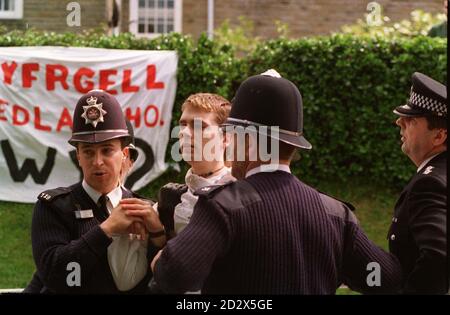 Ein Demonstrator wird heute (Freitag) von der Polizei in Aberystwyth bei einem Protest von rund 200 walisischen Sprachschülern über den Besuch der Königin in der Stadt weggeführt. Der königliche Besuch wurde zu einem abrupten Ende gebracht, als die Königin ihr Engagement an der University of Wales auf Anraten ihres persönlichen Schutzbeauftragten und Dyfed-Powys-Assistenzchefs Keith Turner absagte. Stockfoto