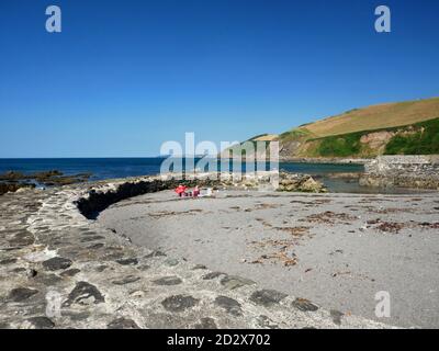 Eine aus Stein gebaute Hafenmauer schützt die Bucht von Portwrinkle, südöstlich von Cornwall. Stockfoto