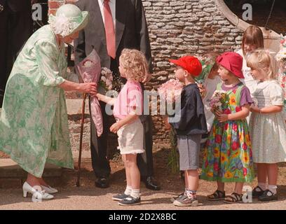 Die Königin Mutter, die heute 96 Jahre alt ist, wird heute Morgen von kleinen Kindern vor der Sandringham Kirche Blumen überreicht. FOTO VON JOHN STILLWELL/PA. Stockfoto