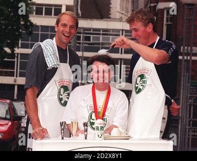 Britische Olympiasieger, die Ruderer Steven Redgrave (links) und Matthew Pinsent (rechts) räumen heute (Donnerstag) in London den schnellsten Washer-Up Großbritanniens, Alan Jarvie, aus East Kilbride, Schottland, auf, nachdem er das "bist du so schnell wie New Fairy Liquid? Washing-up Grand Final. Foto von Michael Stephens. Stockfoto