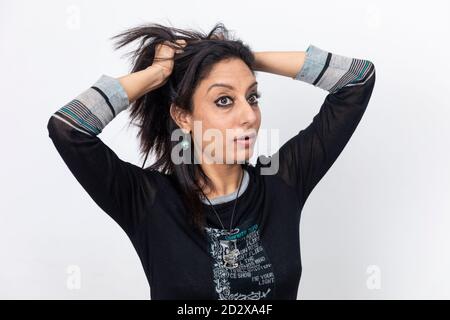Porträt einer indischen Frau mit ihren Fingern in ihren langen Haaren und an ihnen ziehen, wütend und frustriert Dame. Stockfoto