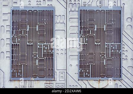 Metallgitter in der Wand in Form einer elektronischen Platine. Technologisch moderner Hintergrund Stockfoto