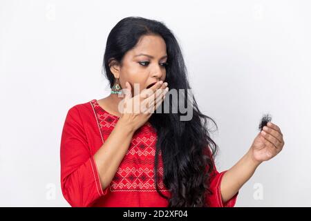 Portrait der indischen Frau mit langen Haaren Gesicht Haarausfall Problem, Haarausfall, halten Haare in der Hand, Schuppen Problem, Alopezie. Stockfoto