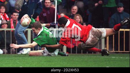 Irlands Dennis Hickie kreuzt in der Ecke trotz der Aufmerksamkeit von Wales Colin Charvis während des heutigen (Samstag) Five Nations Clash im National Stadium, Cardiff . BILD DAVID JONES/PA Stockfoto