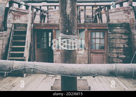 Das Deck eines alten Segelbootes mit einem Mast in der Mitte, einer Leiter und Fenstern. Vintage Holzschiff, Nahaufnahme Stockfoto