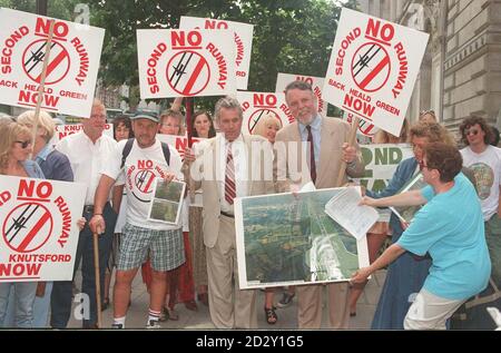 Tatton Independent MP Martin Bell, trägt seinen typischen weißen Anzug, und ehemalige Geisel Terry Waite, mit einem Künstler Eindruck von der vorgeschlagenen Arbeit, Leiter einer Demonstration gegen eine zweite Start-und Landebahn am Flughafen Manchester, außerhalb Downing Street heute (Di), bevor sie in einer Petition an Premierminister Tony Blair. Siehe PA Story UMGEBUNG Runway. Foto von Michael Stephens/PA Stockfoto