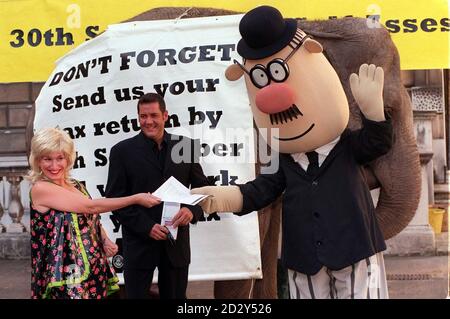 TV-Show-Host, Dale Winton (Mitte) und Comedienne, Gayle Tuesday Hand in ihre Steuererklärungen an Hector - der Cartoon-Taxman - vor Rani der Elefant vor Somerset House in London heute (Dienstag). Unter der Prämisse, dass der Elefant nie vergisst, führt die Fotozelle die Kampagne "Countdown" der Inlandseinnahmen bis September 30 an. Alle Steuerzahler, die wollen, dass die Inland Revnue ihre Steuerrechnung berechnet und sie wissen lassen, wie viel sie bis zum 31 1998. Januar zahlen müssen, müssen ihre Formulare bis zu diesem Datum ausfüllen und zurückgeben. Foto von David Cheskin/PA Stockfoto