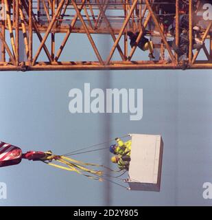 Beamte (links) versuchen, die Demonstranten (rechts) vom Absinken zu überzeugen, nachdem sie einen riesigen Kran bestiegen haben, der heute (Dienstag) für die Installation der 12 Masten verwendet wird, die zur Unterstützung der Struktur des Millennium Dome in Greenwich benötigt werden. Neun Aktivisten, die sich selbst Time Bomb nannten, ketteten sich an den 350 Meter langen Kran und entrollten ein Transparent mit der Aufschrift: Domesday Dome. Foto von David Giles. Siehe PA Story MILLENNIUM Protest. Stockfoto