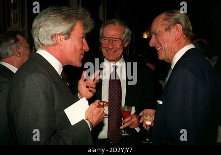 Lord Lichfield chattet mit Prinz Philip, während der Filmkritiker Barry Norman bei einem Empfang der Königin und des Herzogs im Schloss Windsor für Menschen, die sich mit der Kunst beschäftigen, zuschaut Stockfoto