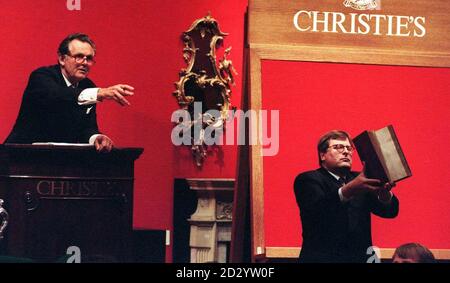 Der Auktionator Lord Himdlip (links) fängt den Bieter ein, da die erste Ausgabe von Chaucers Canterbury Tales aus dem 15. Jahrhundert, gedruckt von William Caxton (rechts abgebildet), heute Abend (Mittwoch) für einen Rekord von 4,621,500 über dem sechsfachen des geschätzten Preises bei Christie's in London verkauft wird. Siehe PA Story SALE Chaucer. Foto von Neil Munns/PA Stockfoto