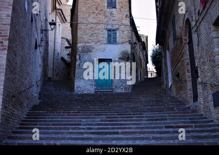Eine Treppe in einem italienischen mittelalterlichen Dorf vor einem verlassenen Haus mit grüner Tür (Corinaldo, Marken, Italien, Europa) Stockfoto