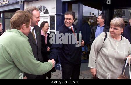 Der Vorsitzende von Sinn Fein, Mitchell McLaughlin, und der Chefunterhändler Martin McGuinness (zweiter von links) treffen sich während des Wahlkampfs für die Europawahl mit den Einheimischen. Stockfoto