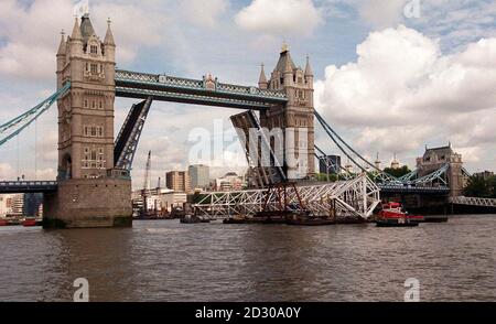 Die Tower Bridge wird angehoben, während der letzte Abschnitt des British Airways London Eye den Weg entlang der Themse bis zum Ort führt, an dem das Rad derzeit montiert wird. Das größte Riesenrad der Welt wird Besuchern einen atemberaubenden Blick ermöglichen. * ... auf der 30-minütigen Attraktion, da das Rad 400 Meter über der Londoner Skyline klettern wird - dreimal so hoch wie die Tower Bridge. Stockfoto