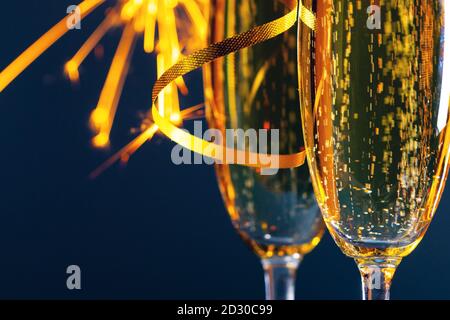 Zwei Gläser Champagner und Wunderkerzen leuchten im Hintergrund Konzept der Neujahrsparty Stockfoto